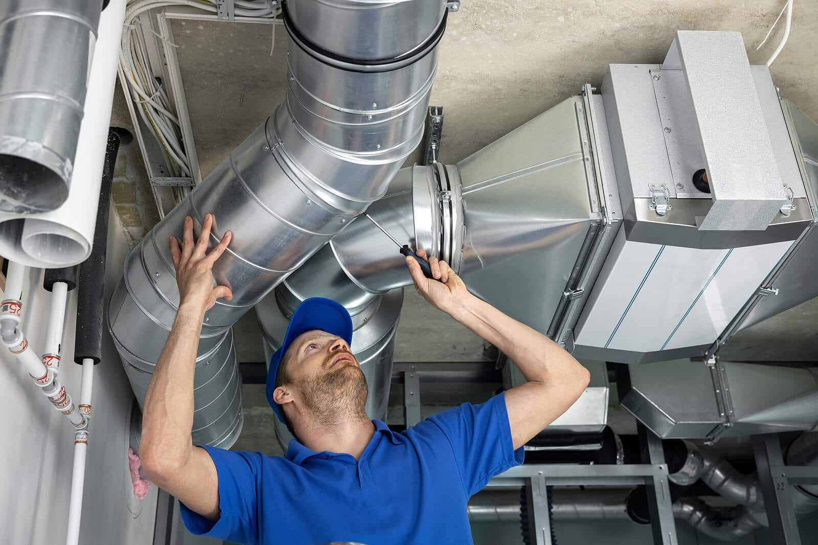 HVAC technician inspecting and repairing air ducts in Clovis